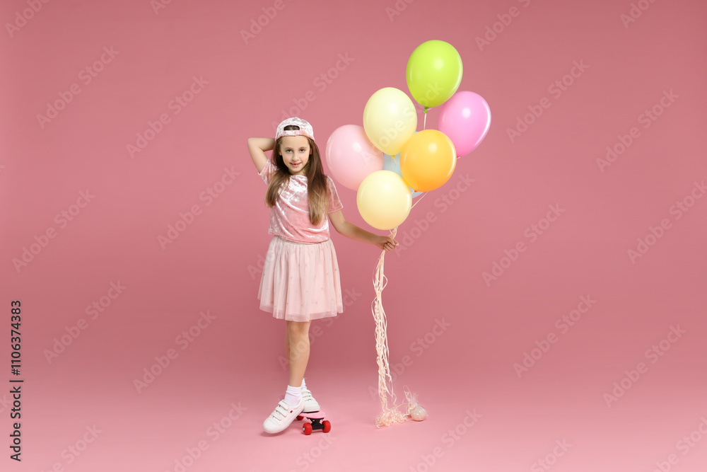 Little girl with colorful balloons and penny board on pink background Little girl with colorful balloons and penny board on pink background