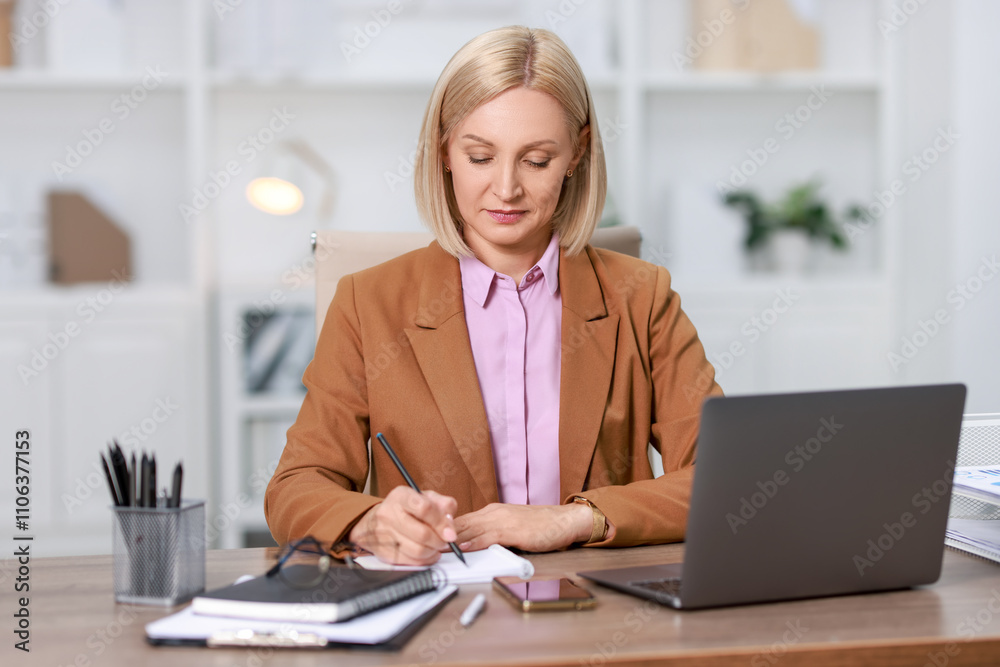 Middle aged woman working at table in office Middle aged woman working at table in office
