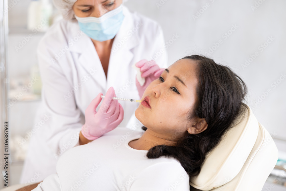 Skilled cosmetologist performing procedure for injecting beauty injections for the patient Skilled cosmetologist performing procedure for injecting beauty injections for the patient