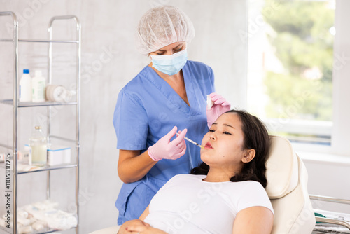 Woman getting facial beauty treatment by professional medicine worker in medical center