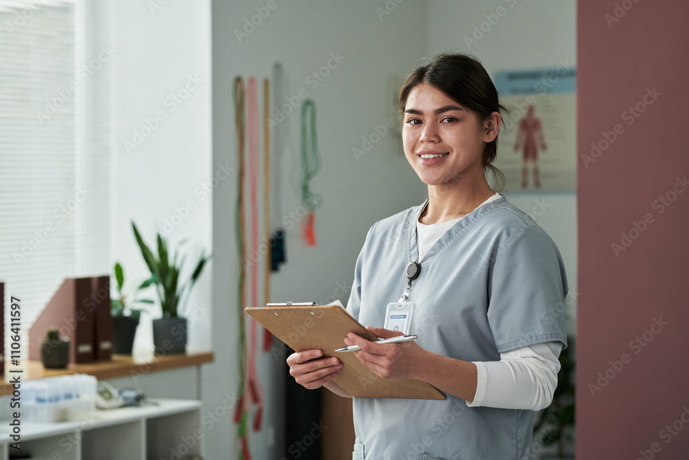 Smiling nurse holding clipboard while standing in a modern medical facility. Medical equipment and indoor plants seen in background providing a serene atmosphere Smiling nurse holding clipboard while standing in a modern medical facility. Medical equipment and indoor plants seen in background providing a serene atmosphere