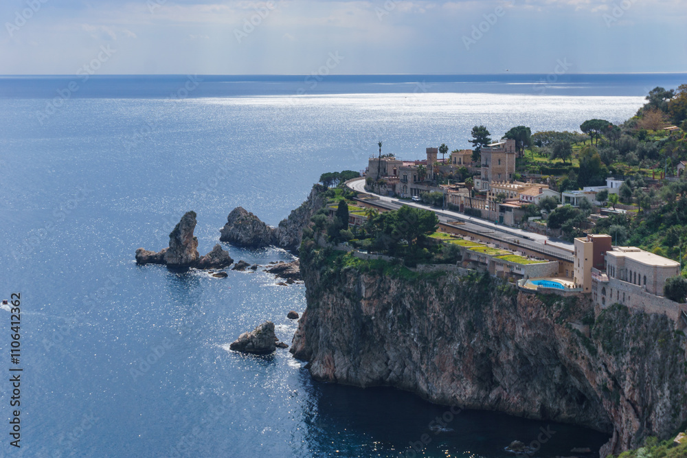 View at cliff on the coastline in Taormina with clear turquoise water at the mediterranean sea on a sunny day, Sicily, Italy View at cliff on the coastline in Taormina with clear turquoise water at the mediterranean sea on a sunny day, Sicily, Italy