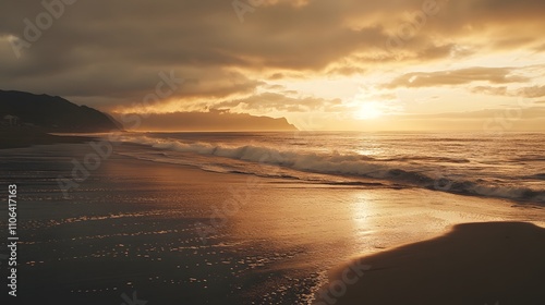 Golden sunset over ocean waves on sandy beach.