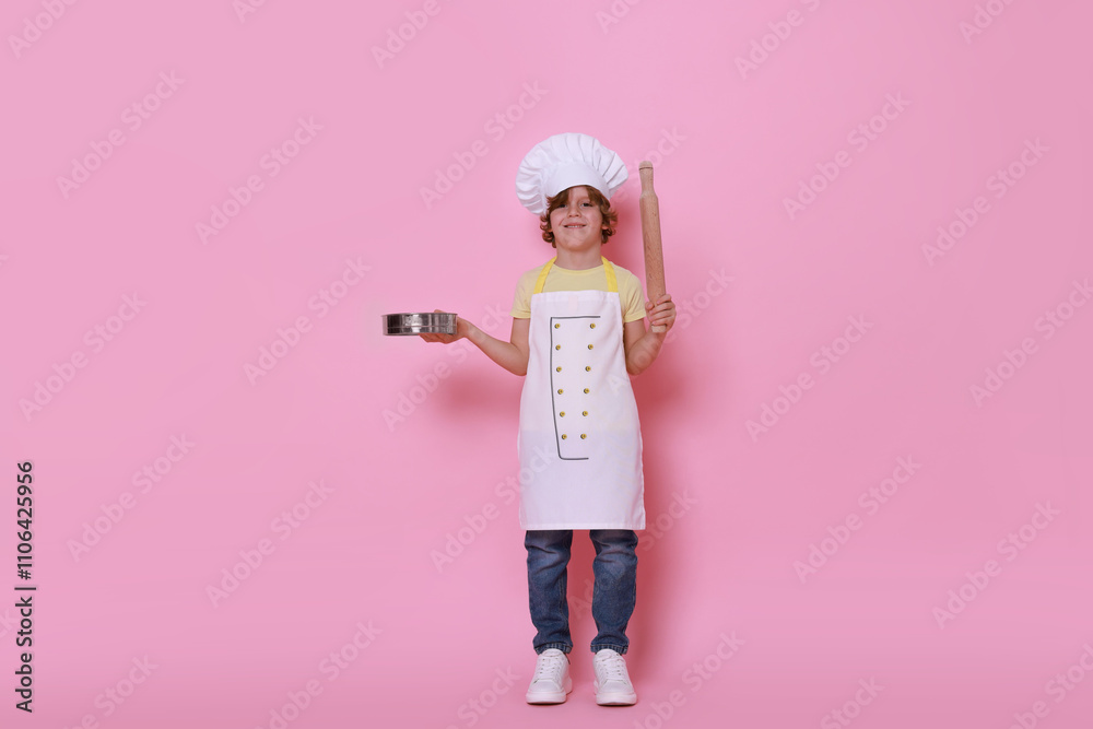 Little boy with utensils pretending to be chef on pink background. Dreaming about future profession Little boy with utensils pretending to be chef on pink background. Dreaming about future profession