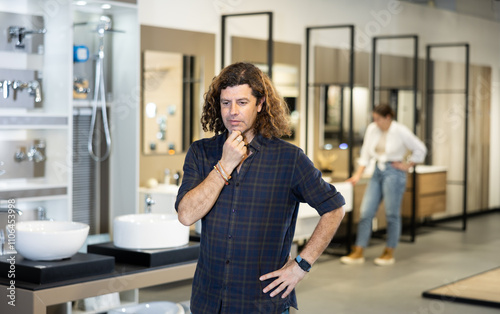 Confident man picking new bathroom furnishings in hardware store