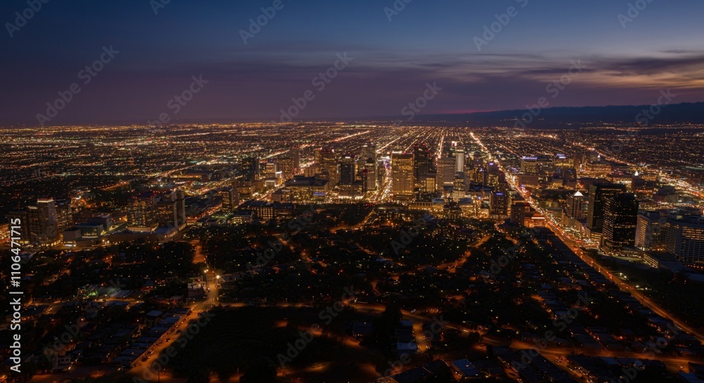 Obraz premium Aerial view of a cityscape with lights glowing at twilight