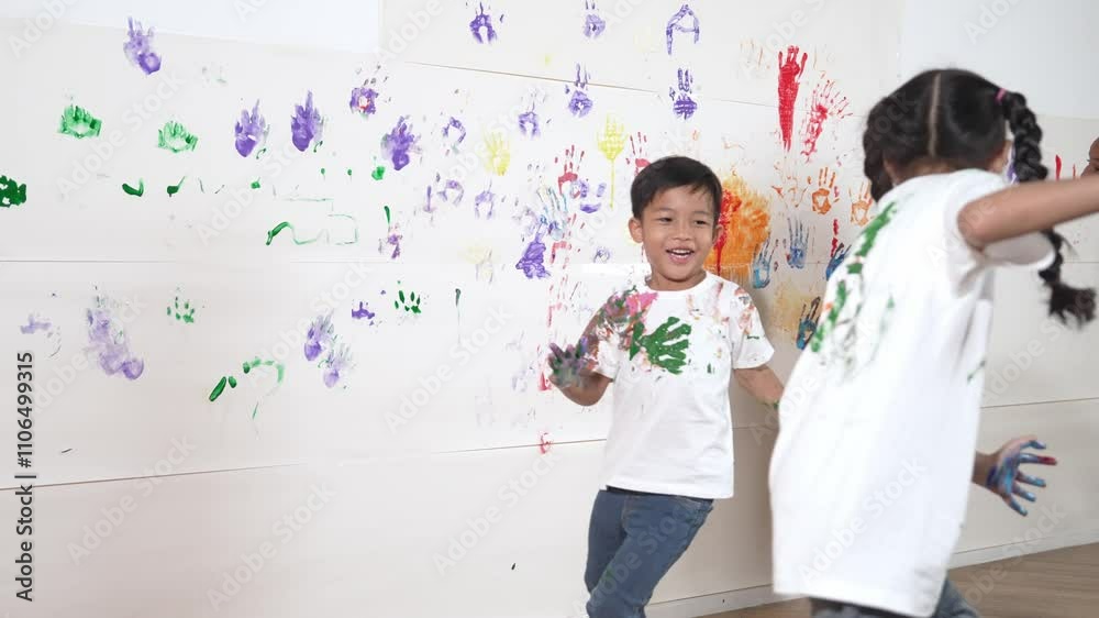 Playful children playing and running with colorful stained hand in front of white background. Funny happy multicultural students enjoy attending in art lesson. Creative activity concept. Erudition. Playful children playing and running with colorful stained hand in front of white background. Funny happy multicultural students enjoy attending in art lesson. Creative activity concept. Erudition.