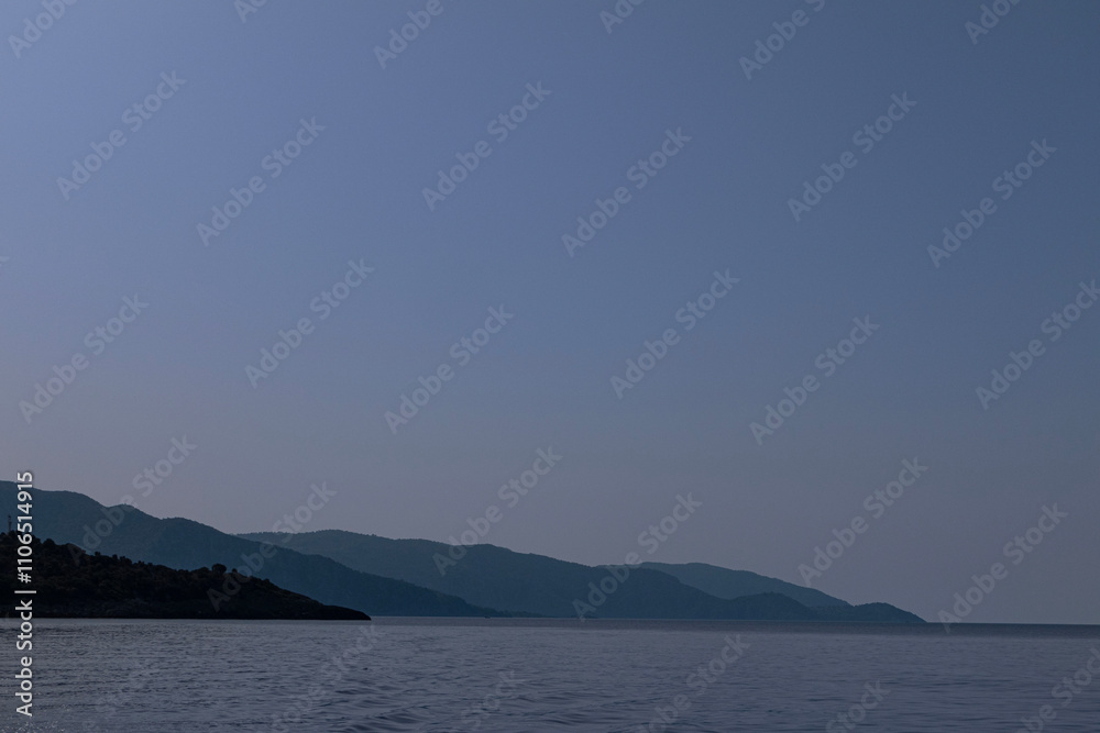 Gently hilly headland coming down to the sea, under a cloudless sky. Gently hilly headland coming down to the sea, under a cloudless sky.