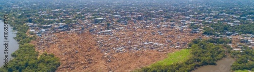 Aerial view of a densely populated area near a river, highlighting urban development and nature.