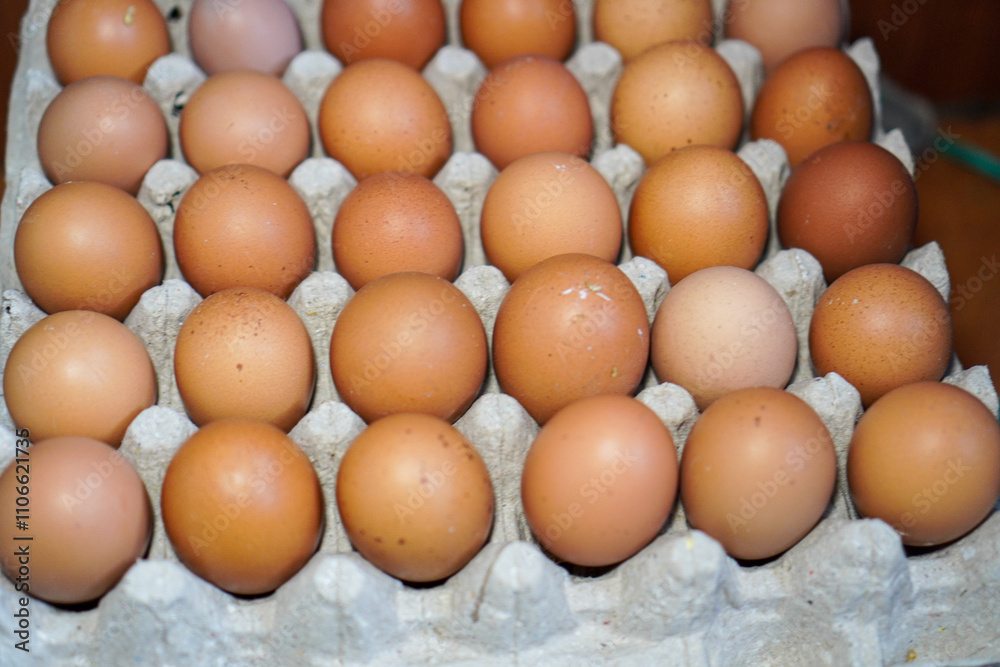 Close-up view of a carton filled with a dozen fresh brown eggs. A Dozen Brown Eggs in Cardboard Carton Background. Close-up view of a carton filled with a dozen fresh brown eggs. A Dozen Brown Eggs in Cardboard Carton Background.