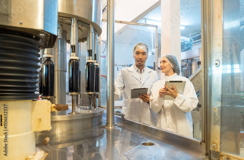 Engineer staff man and woman two person smile talk and inspect check quality control working job in beverages vats barrels modern technology factory production pattern industry plant in warehouse.