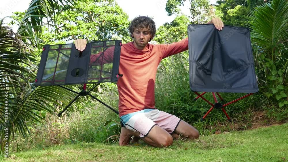 man holds folding super light table and chair for camping and hiking, natural background man holds folding super light table and chair for camping and hiking, natural background