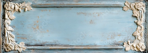 A weathered wooden frame with an aged paint finish and faded blue hues, featuring floral carvings along the edges. The frame rests against a light, neutral background with warm, soft light filtering