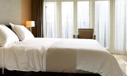 Serene Bedroom Interior Design: Sunlight Streaming Through Sheer Curtains onto Crisp White Bedding