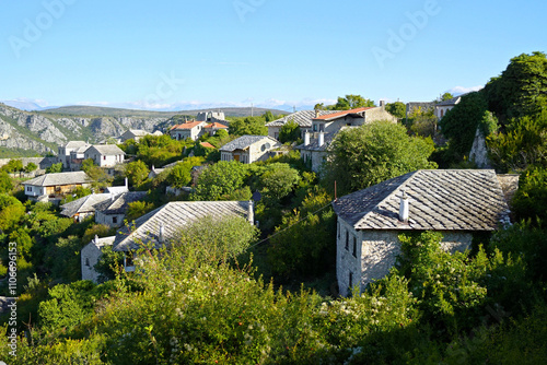 Panorama of Pocitelj taken during a trip to beautiful places in Bosnia and Herzegovina. Idyllic view of the historical district with old stone houses in Ottoman style, surrounded by greenery. photo