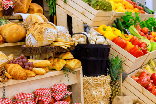 Fototapeta Naklejka Na Ścianę i Meble -  Brightly colored fruits, vegetables alongside freshly baked bread create lively atmosphere at local farmers market