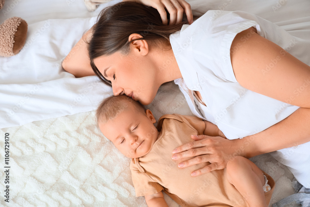 Happy mother kissing her little baby on bed, closeup Happy mother kissing her little baby on bed, closeup