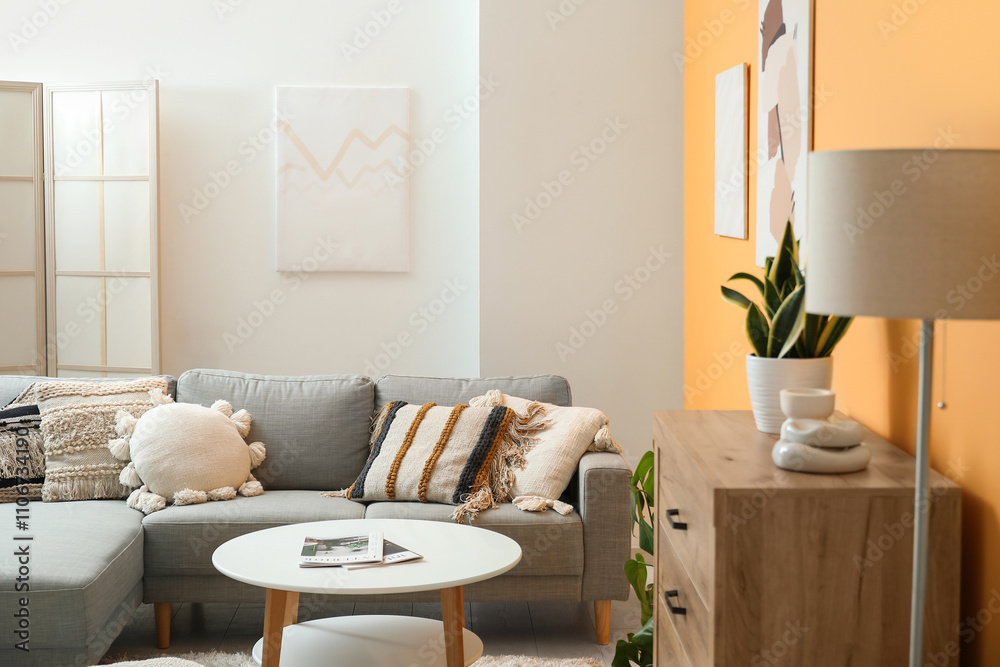 Fototapeta premium Comfortable sofa, picture and coffee table in interior of living room