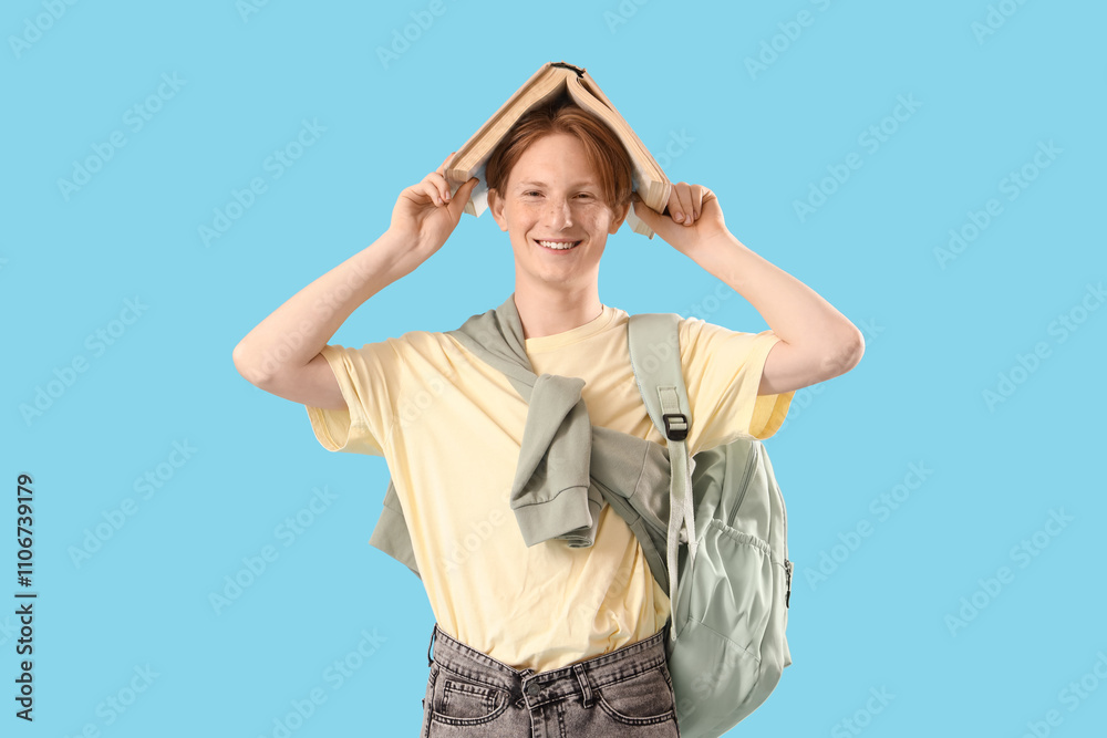 Male student with backpack and book on blue background Male student with backpack and book on blue background