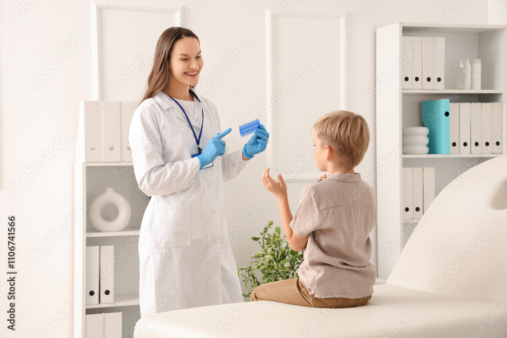 Fototapeta premium Female doctor with head lice comb and little boy with pediculosis in clinic
