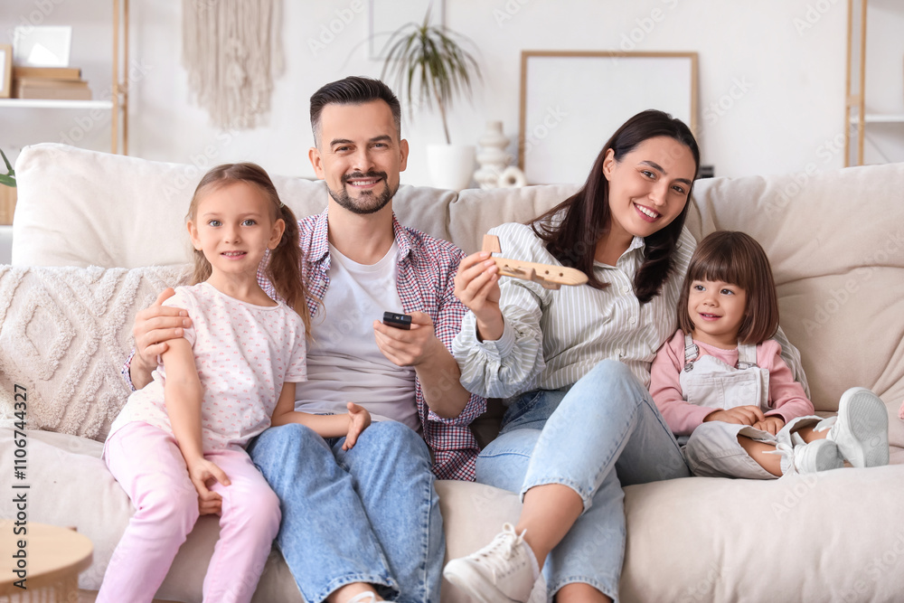 Beautiful happy family watching TV on sofa at home Beautiful happy family watching TV on sofa at home