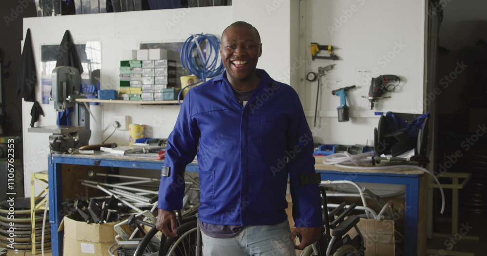 Portrait of an African American male worker in a workshop at a factory making wheelchairs, looking t Portrait of an African American male worker in a workshop at a factory making wheelchairs, looking t