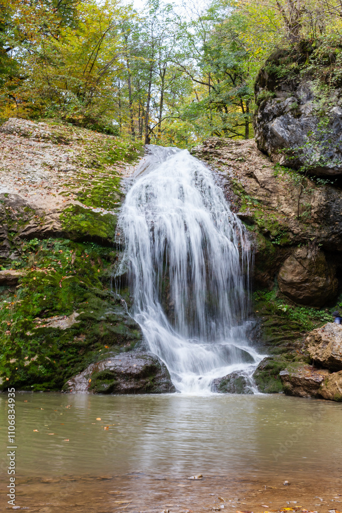 Fototapeta premium a waterfall in the summer, rushing streams and jets of water and turned into a huge shower of water