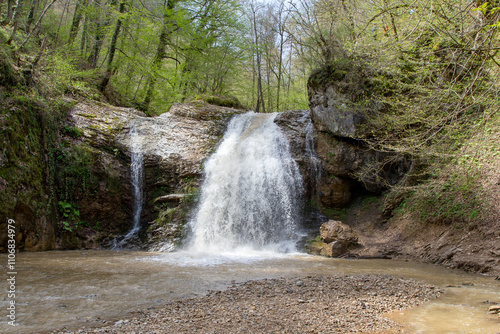 a waterfall in the summer, rushing streams and jets of water and turned into a huge shower of water
