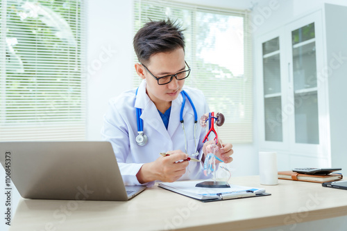 A male doctor sits at a desk in a hospital, discussing male urinary tract models and conditions like enlarged prostate, prostatitis, cystitis, urinary tract infections.Early diagnosis aids effective photo