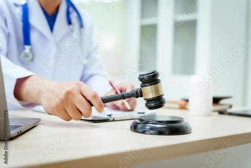 A male doctor sits at a desk, holding a signature pen, discussing medical law. This law safeguards patients and medical institutions during examinations and treatments, ensuring ethical healthcare