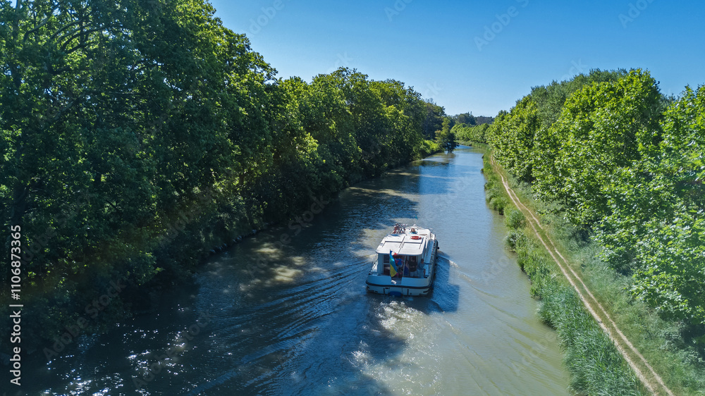Naklejka premium Vacation boat in Canal du Midi, family travel cruise by barge penichette, holidays in Southern France
