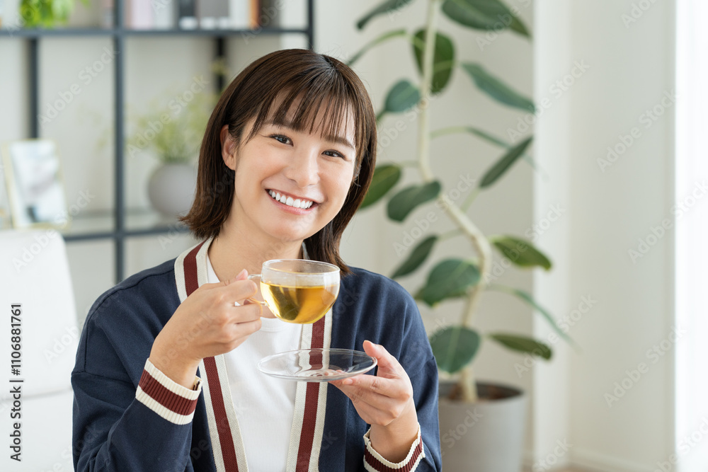 リビングでハーブティーを飲む若い女性 リビングでハーブティーを飲む若い女性