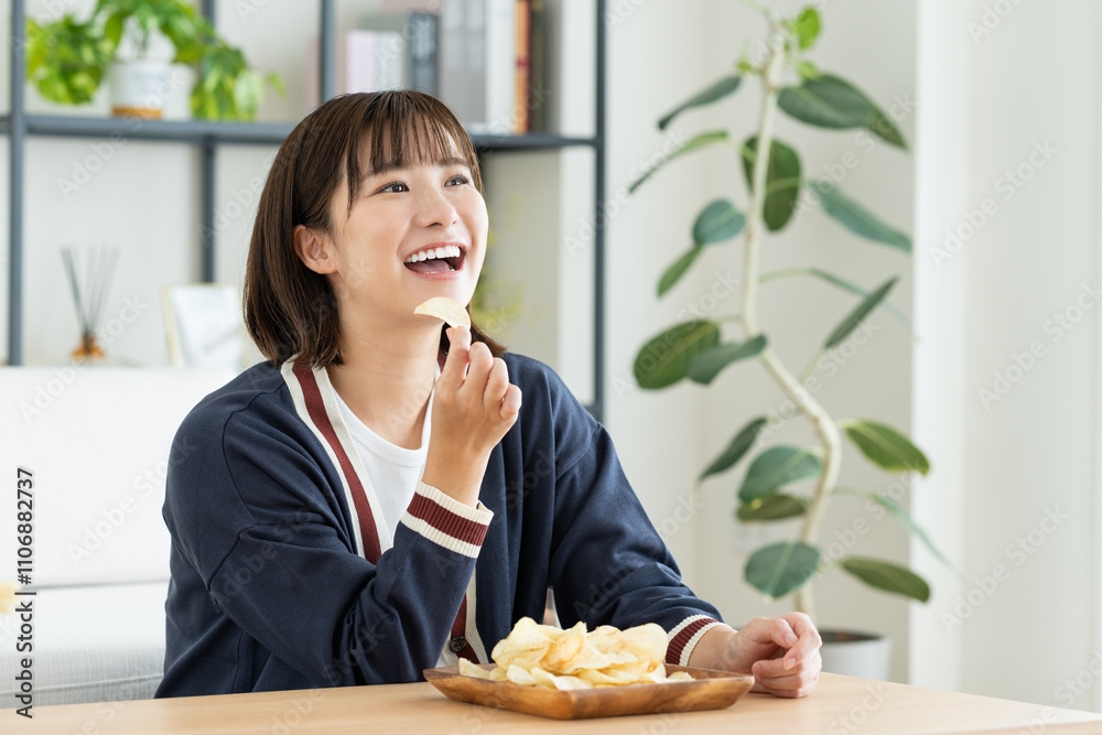 リビングでポテチを食べる若い女性 リビングでポテチを食べる若い女性