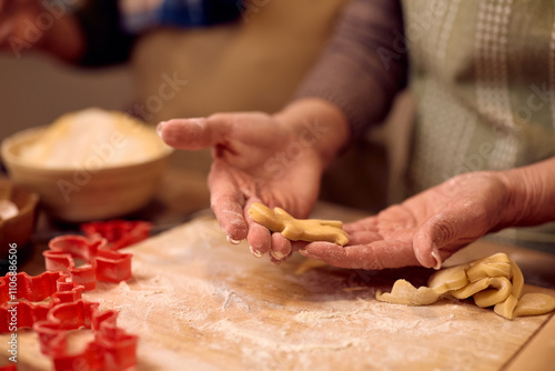 Close up of senior woman making gingerbread cookies for Christmas.