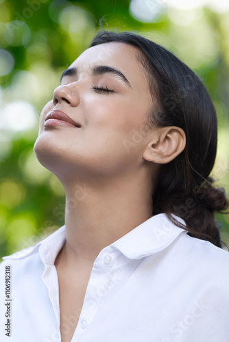 Relaxed happy refreshing young south asian woman taking a deep breath of clean unpolluted air in urban park, good summer, summer wellness, sunlight exposure concept image