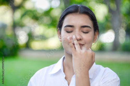 South Asian young woman practicing yoga breathing technique, surya bheda pranayama, the sun breathing with one nostril