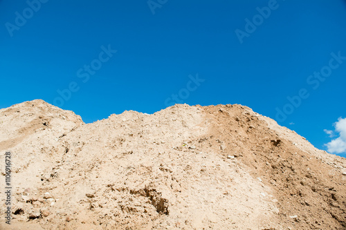 mountain of sand against blue sky