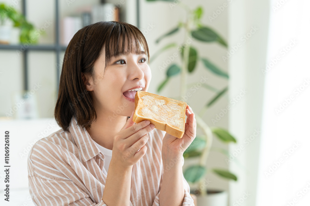トーストを食べる若い女性 トーストを食べる若い女性