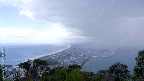 Rain coming across Tauranga - New Zealand. Calm view from top of the mountain photo