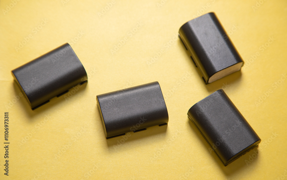 Camera batteries on the yellow background. Camera batteries on the yellow background.