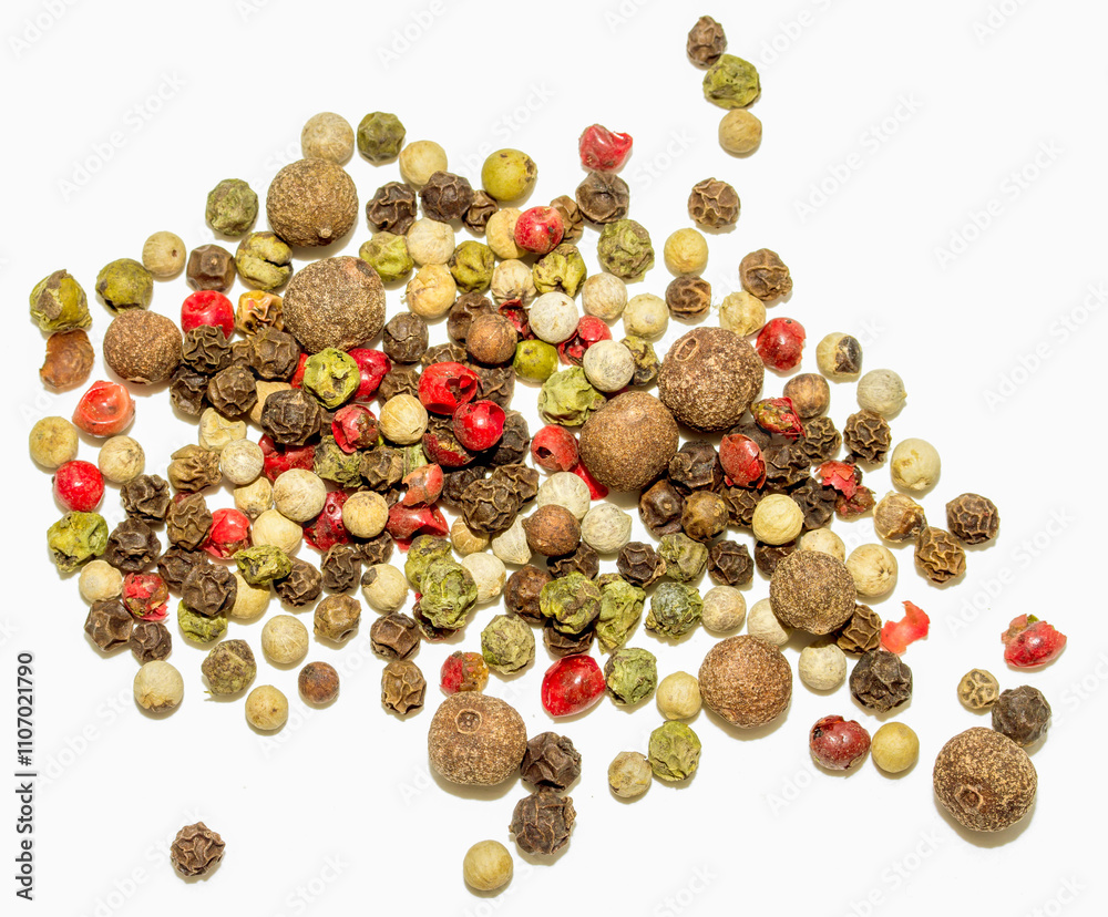 A bunch of different colored peppers are scattered on a white background A bunch of different colored peppers are scattered on a white background