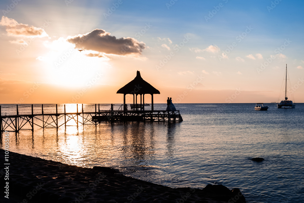 Couple de mariés sur ponton au coucher de soleil, île Maurice Couple de mariés sur ponton au coucher de soleil, île Maurice