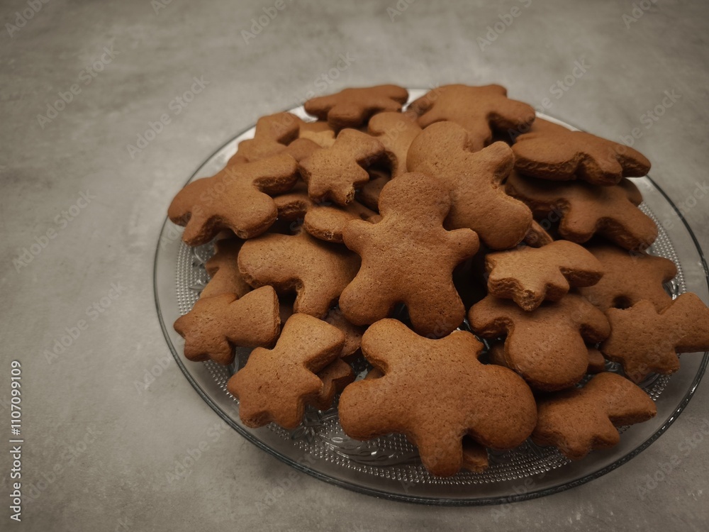 Gingerbread men and comets shaped cookies arranged on a glass plate, capturing the essence of christmas baking and holiday cheer