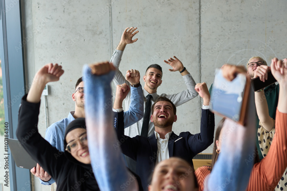 Obraz premium A diverse team of business professionals ecstatically celebrating their success in a modern office, expressing triumph and unity after achieving their goals