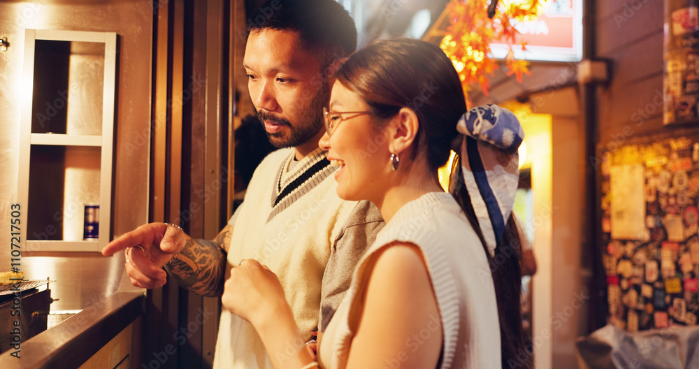 Street food, choice and pointing with Japanese couple at market for culture festive, nutrition or health. Travel, shopping and cuisine with man and woman at Japan city vendor for date and holiday Street food, choice and pointing with Japanese couple at market for culture festive, nutrition or health. Travel, shopping and cuisine with man and woman at Japan city vendor for date and holiday
