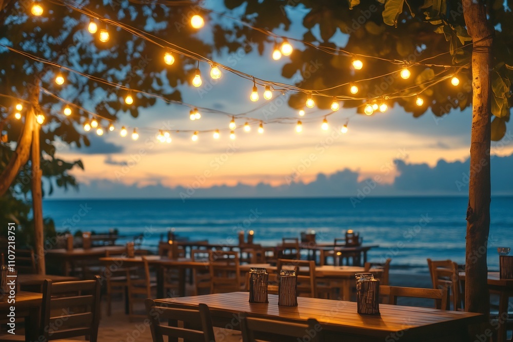 Fototapeta premium Beachside Tables Set Under Glowing String Lights at Sunset