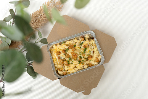 Fototapeta Naklejka Na Ścianę i Meble -  Takeaway pasta with mini shrimps and melted cheese in a cardboard box for delivery