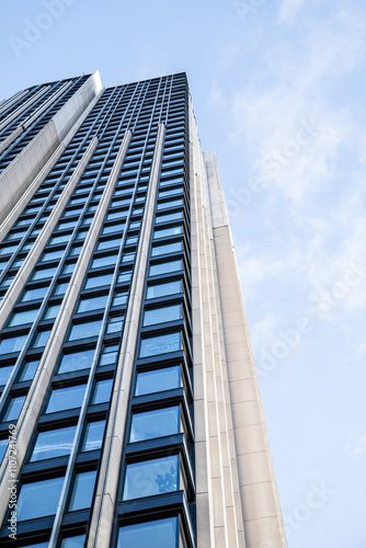 Building with windows, view from below, clouds in the sky