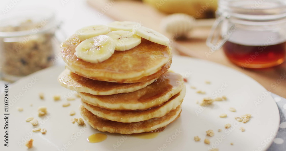 Image of pancakes on table with syrup and bananas