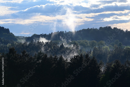 Morgennebel kurz vor Sonnenaufgang in hügeliger Waldlandschaft photo